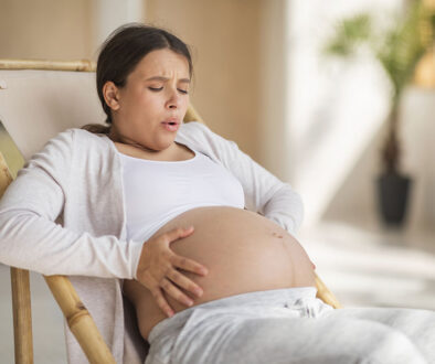 Latin American Woman Holding Her Pregnant Belly in Pain Fibroids and Pregnancy