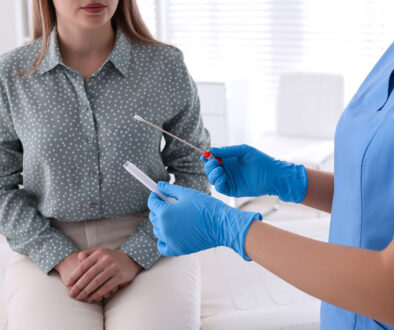 A Doctor Wearing Gloves Holding a Swab for an Std Test in Front of a Female Patient Sitting on an Exam Table Most Common STD