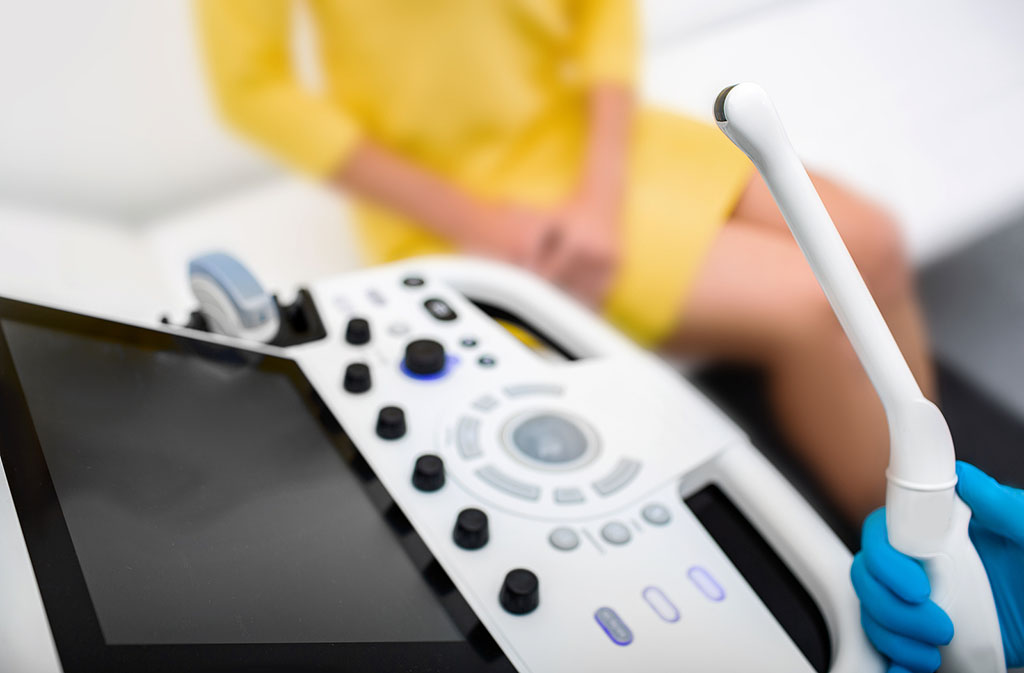 Closeup of a Gynecologist Holding a Sensor Wand With a Patient Sitting in the Background What Does a Transvaginal Ultrasound Show