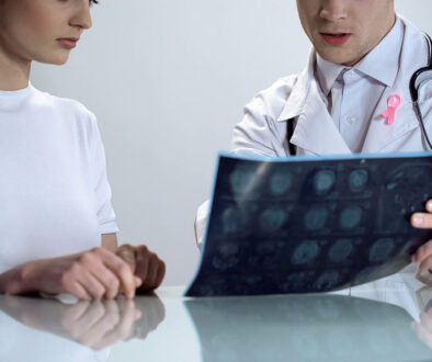 Closeup of a Gynecologist Sitting Beside a Female Patient Showing Her Abnormal Mammogram Results