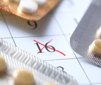 Closeup of Birth Control Pills on a Calendar With an X Marked Over a Specific Date Period Stop on Birth Control