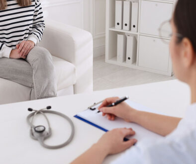 Closeup Of A Gynecology Doctor Writing On A Clipboard With A Patient Sitting On A Couch In Front Of Her HPV Vs Herpes