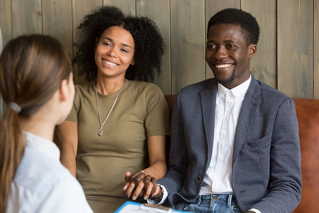 An African American Couple Holding Hands Sitting With A Fertility Specialist Female Fertility Testing